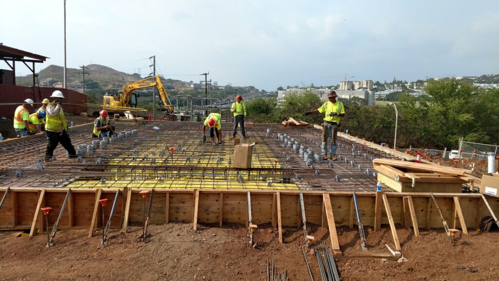 Crew tying rebar and setting forms for a concrete foundation
