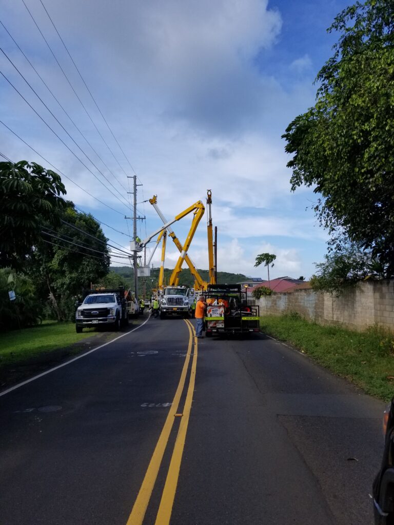 Bucket trucks working on overhead lines above a road