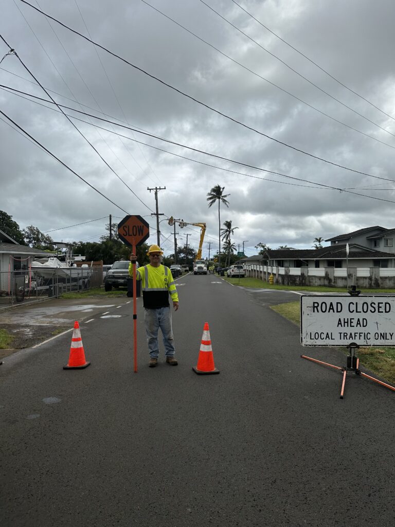 Mana flagger with a STOP paddle at a road closure